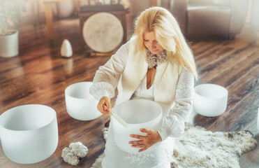 Woman playing on a crystal bowl. Ceremony space.