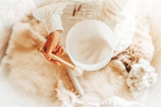 Woman playing on a crystal bowl. Ceremony space.