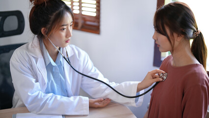 Asian psychologist women listening heartbeat of patient with stethoscope and giving counseling about mental health therapy while female patient stress and anxiety with psychological health problem