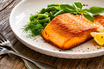 Seared salmon steak with green bean and lemons on wooden table
 - obrazy, fototapety, plakaty