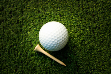 Golf balls and tees are placed on artificial grass.