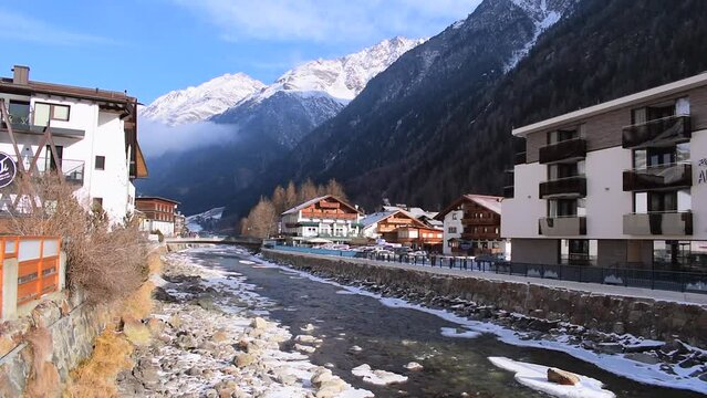 Beautiful view of a frozen river flowing through the &Ouml;tztal Valley in S&ouml;lden Alpine resort. The traditional Austrian town of Solden during the peak ski season in the winter months. Mountain backdrop.