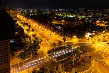 Aerial view street in Alicante, Spain, night time. Road with palm trees and cars, night photos.