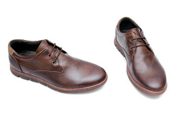Detalhe de sapato masculino de cor castanha em fundo branco.