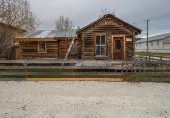 Fototapeta na wymiar Historic log cabin with ladder and fence in Dawson City, Yukon, Canada