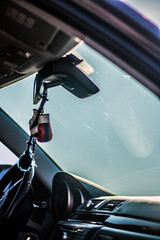 A keychain in the shape of boxing gloves hangs on the rearview mirror in the car.