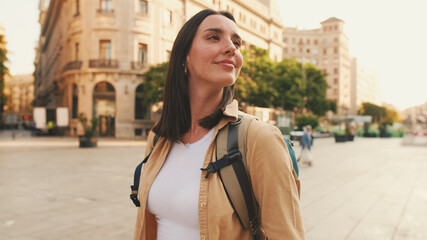 Close up, traveler girl, with backpack on her shoulders, walks in the historical part of European city