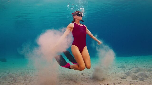 Set of five short clips about woman freediver diving and swimming underwater at sunset. Woman freediver in pink suit swims underwater in Indonesia at sunset