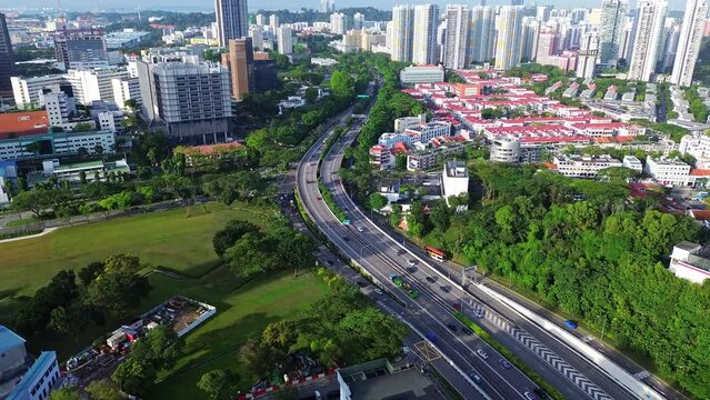 Aerial 4k footage of Singapore city skyline with residential buildings and cars during bright sunny day.