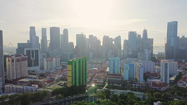 Aerial 4k footage of Singapore city skyline with residential buildings and cars during bright sunny day.