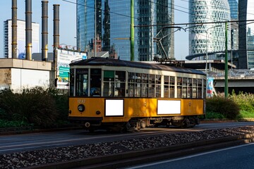 Naklejka premium Billboards on an old yellow tramway in Milan.