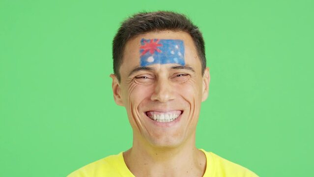 Man with a australian flag painted on the face smiling
