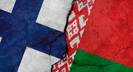 Fototapeta premium Flags of Finland and Belarus, texture of concrete wall with cracks, grunge background, military conflict concept