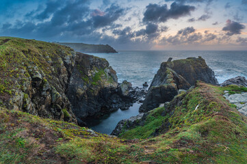 Fototapeta na wymiar Beautiful dramatic Summer dawn over Lizard Point in Cornwall UK with lovely glowing sky and clouds