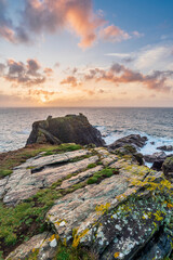 Fototapeta na wymiar Beautiful dramatic Summer dawn over Lizard Point in Cornwall UK with lovely glowing sky and clouds