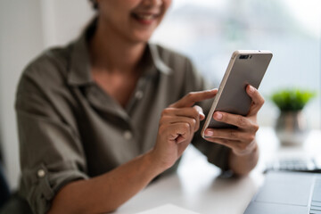 Asian casual businesswoman use smartphone to checking growth finance report of new startup project