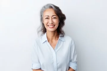  Portrait of Asian senior woman posing on white wall background. © Virtual Art Studio