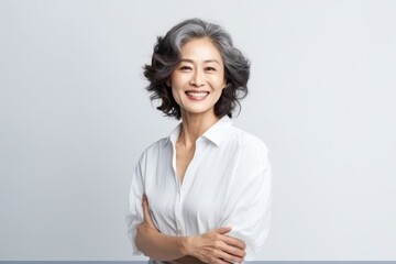 Portrait of Asian senior woman posing on white wall background. - obrazy, fototapety, plakaty