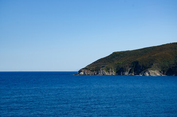 Sky,  sea and to the left a wedge of land .