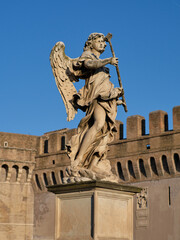 Fototapeta na wymiar Statue of an angel at Castel Sant'Angelo (Mausoleum of Hadrian), landmark roman building and Papal fortress and prison in Rome, Italy 