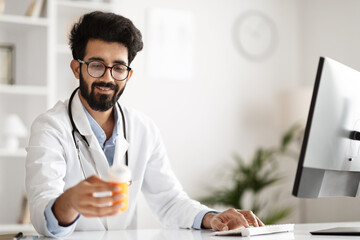 Focused Healthcare Professional Using Clinic PC, Holding Drugs