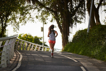 Fototapeta na wymiar young asian woman jogging running in park
