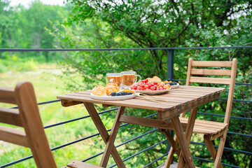 Lovely breakfast outdoors. Table set on the summer terrace. Fruits and berries, croissants and...
