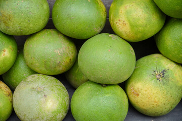 Group of fresh pomelo (Citrus maxima or Citrus grandis) fruits on display at traditional market, in indonesia called Jeruk Bali. pile of pomelo