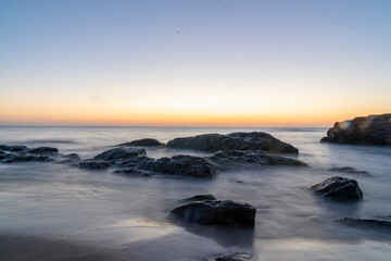 Ocean waves crash at a Pacific Ocean sunset