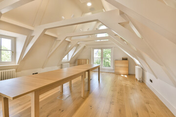 a room with wood flooring and an attic style window in the room is very large, white walls are...