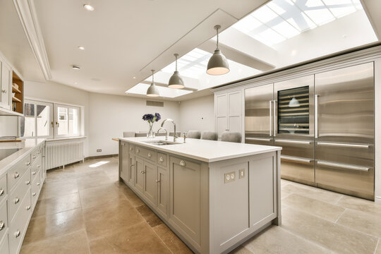 a kitchen with an island and skylight over the sink area in this modern, light - filled kitchen space