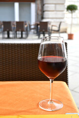 A glass of red wine on an outdoor street cafe restaurant table