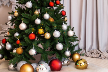 Fototapeta premium A bright Christmas tree decorated with toys stands in the room. AI GENERATE