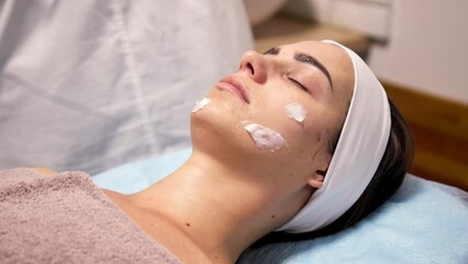 Cosmetologist cosmetologist applies cosmetic gel peeling mask, professional procedure in beauty clinic salon for client. Skin care and cosmetology spa concept.