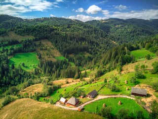 Aerial Drone View: Carpathian Mountain with Old Farm Houses in Sunlight. European Majestic Nature Landscape.