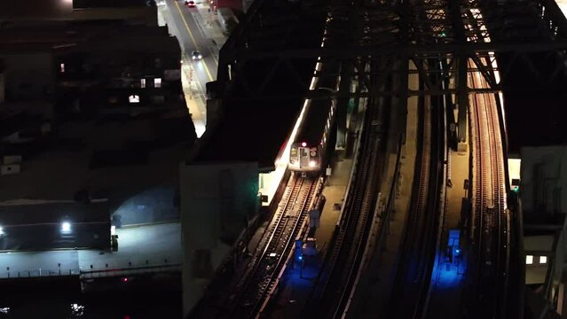 Drone footage of an abve ground subway at night