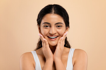 Skincare Concept. Beautiful young indian woman touching face and looking at camera
