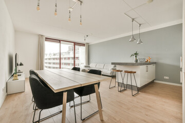 a dining room with wood flooring and light blue walls in the room is very modern, but it's all white