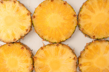Pineapple juicy yellow slices on a white background.