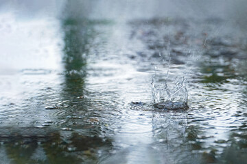 Drops of rain that fall on the asphalt when it rains. close-up rain drops. Drops of heavy rain in a...
