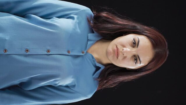 Vertical Video of Woman looking accusingly at camera.