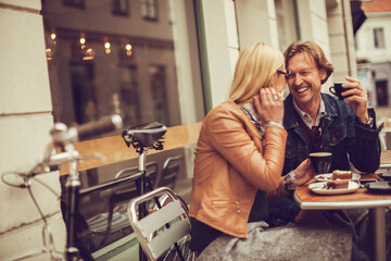 Middle aged Caucasian couple having coffee and desserts in a outdoor café in the city