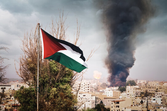 flag of Palestine on the mountain on the background of houses in the city.the war in the Middle East. explosion with black smoke in the city.