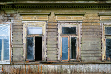 Fototapeta na wymiar An old, abandoned, vandalized wooden house. Wooden architecture, desolation, loneliness.