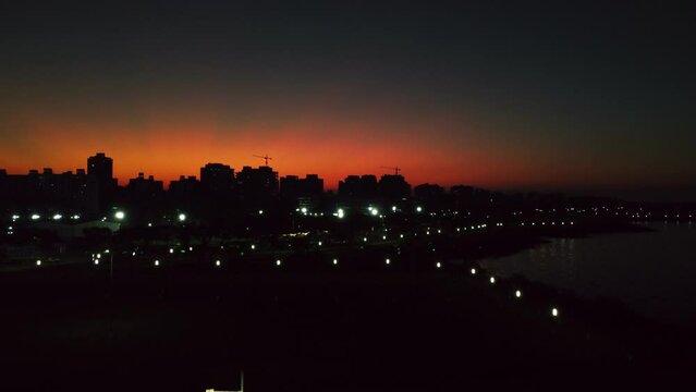 Magic orange sunset over dark night city, late evening