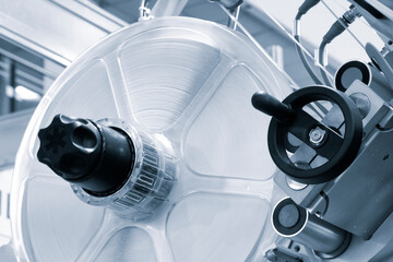 Fragment of the conveyor of sticking labeling machine. Abstract industrial background.