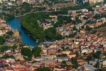 Aerial view of Tbilisi Old Town cityscape with ancient houses,  trees and  Kura river, Georgia, Europe