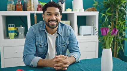 African american man smiling confident sitting on table at dinning room
