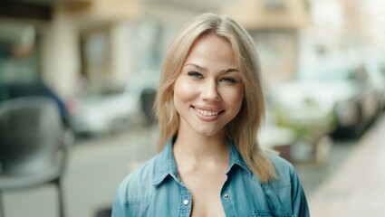 Young blonde woman smiling confident standing at street