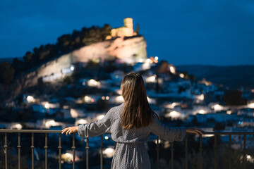 Woman in travel, Asian woman in blue dress looking at the old city of Montefrío at night in Granada, Spain - obrazy, fototapety, plakaty